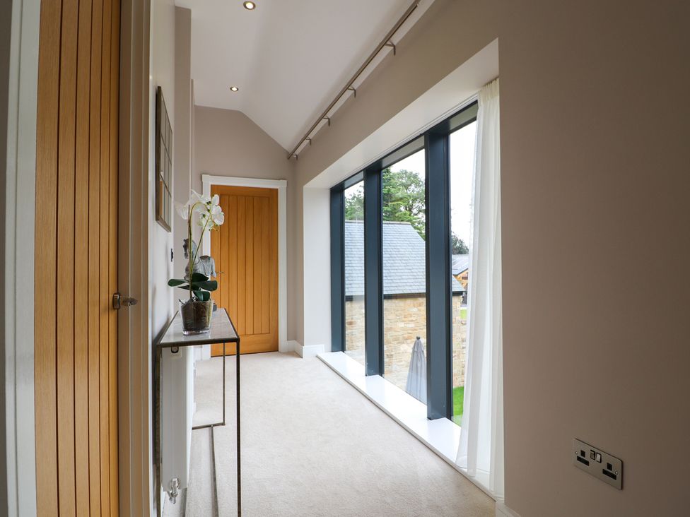 A hallway with a door and window at Northumberland Luxury Stays - The Chivits near Amble