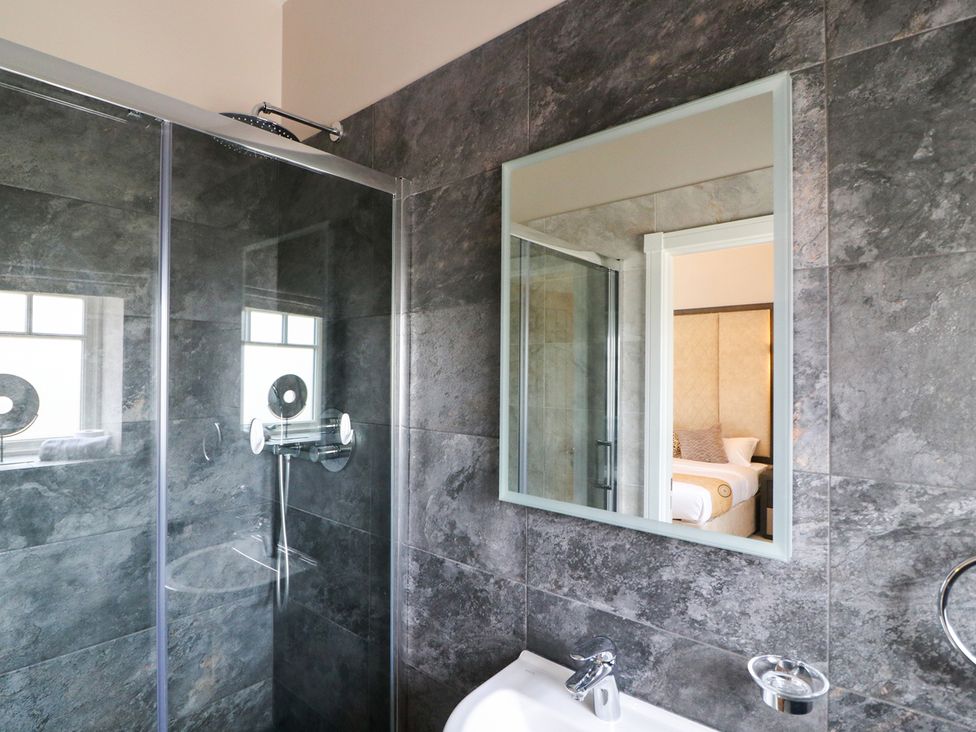 A bathroom with a shower and mirror at Northumberland Luxury Stays - The Chivits near Amble