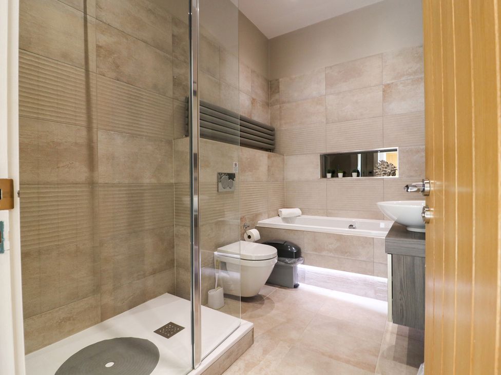 A bathroom with a shower, bathtub, toilet, and sink at Northumberland Luxury Stays - The Chivits, West Chevington near Amble