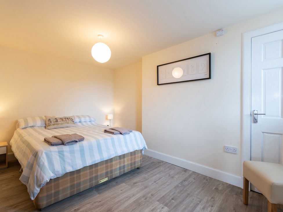 A bedroom with a bed and nightstand at Cellardyke 3-Bed House, Sleeps 6 with Sea Terrace in Cellardyke