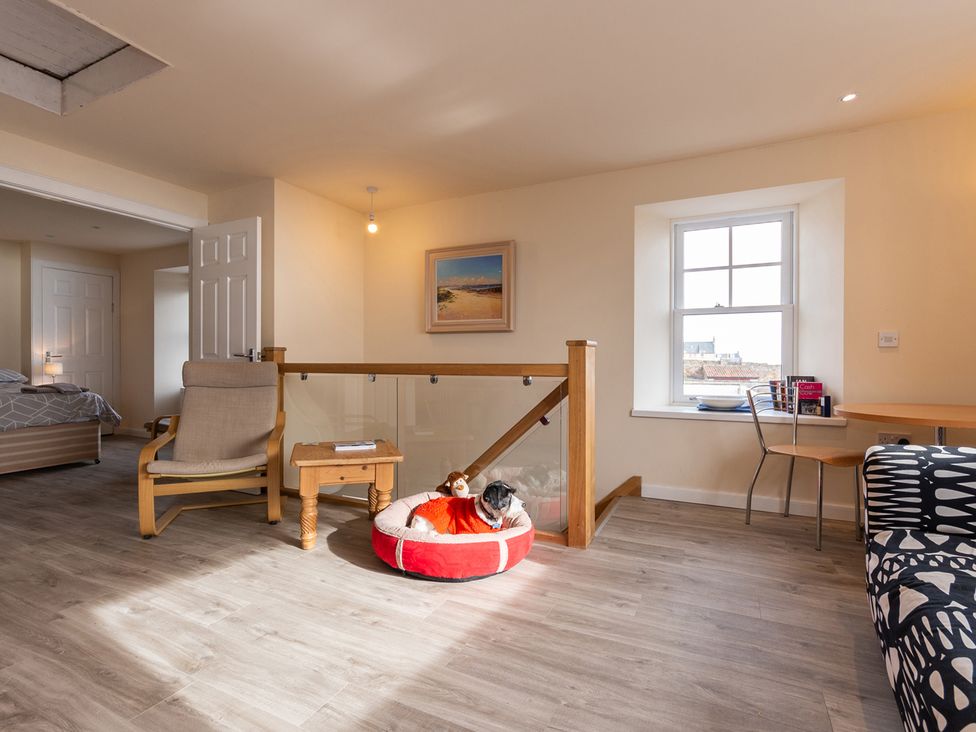 A living room with an armchair and dog bed at Cellardyke 3-Bed House, Sleeps 6 with Sea Terrace in Cellardyke