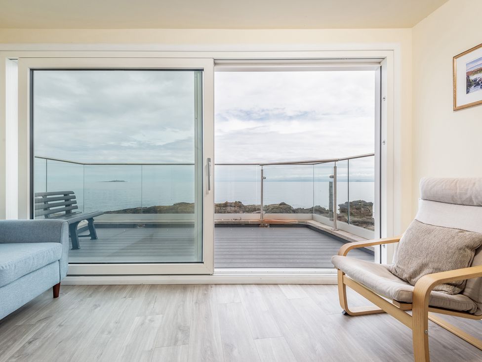 A living room with a sliding door and seating at Cellardyke 3-Bed House, Sleeps 6 with Sea Terrace, Cellardyke