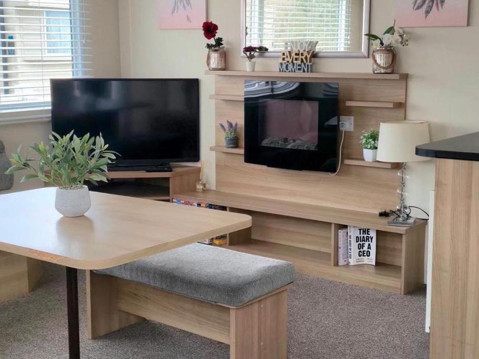A living room with a television and a coffee table at Port Haverigg Cabin Sleeps 4 Steel Green near Haverigg
