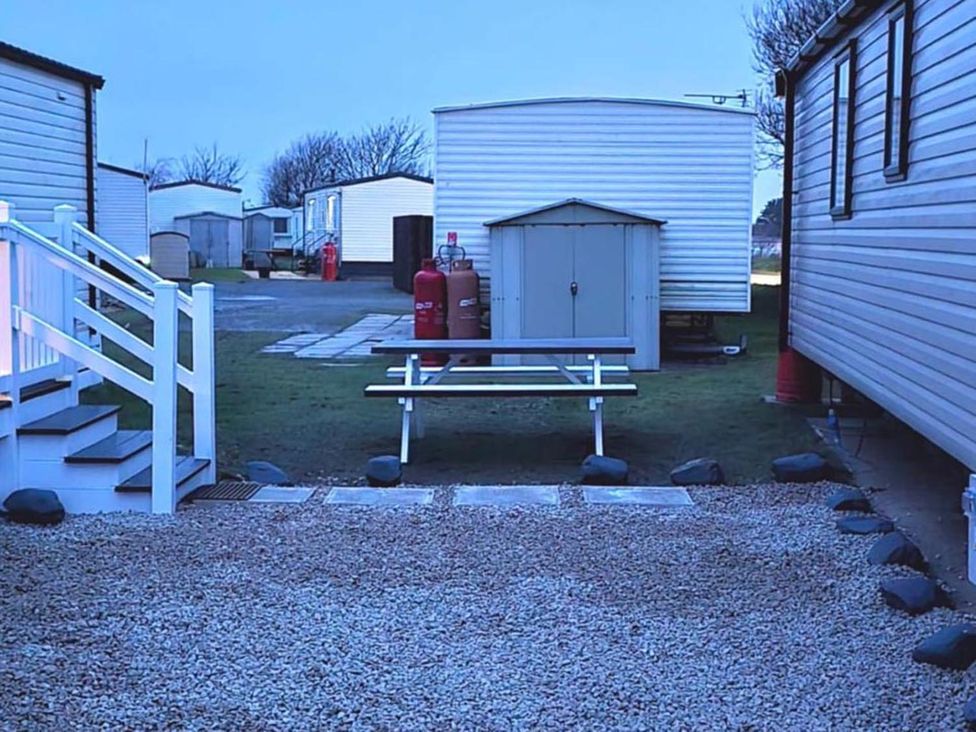 An outdoor area with a bench and gas cylinders at Port Haverigg Cabin Sleeps 4 in Steel Green near Haverigg