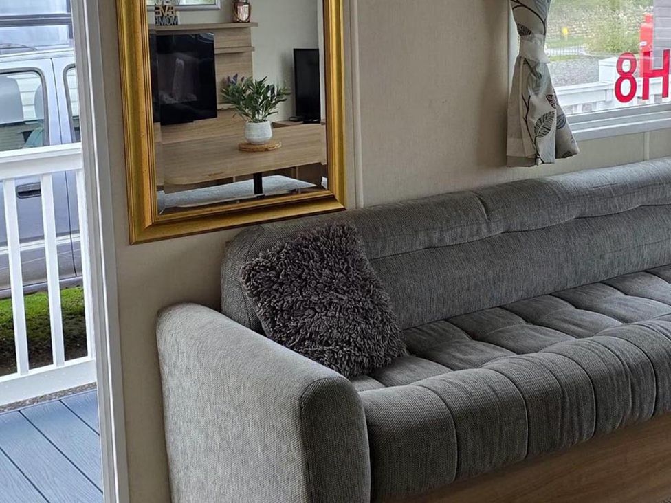 A living room with a sofa and a television at Port Haverigg Cabin Sleeps 4, Steel Green near Haverigg