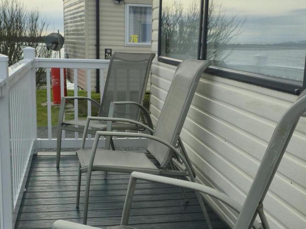 A seating area with chairs on a deck at Port Haverigg Cabin Sleeps 4, Steel Green near Haverigg