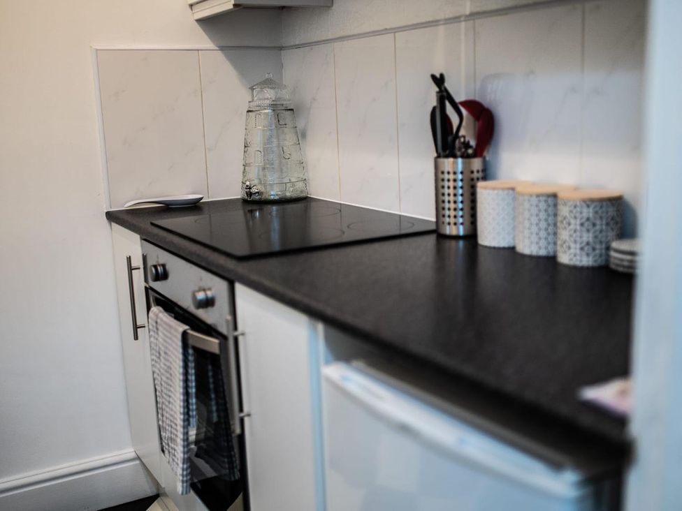 A kitchen with stove, oven, and glass container at Rose Apartment 2-Bed Apt, Sleeps 4 Town Centre Ayr