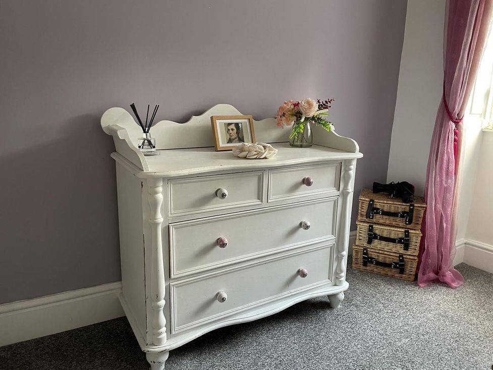 A dresser with a photo frame and flowers at Rose Apartment 2-Bed Apt, Sleeps 4 Town Centre Ayr