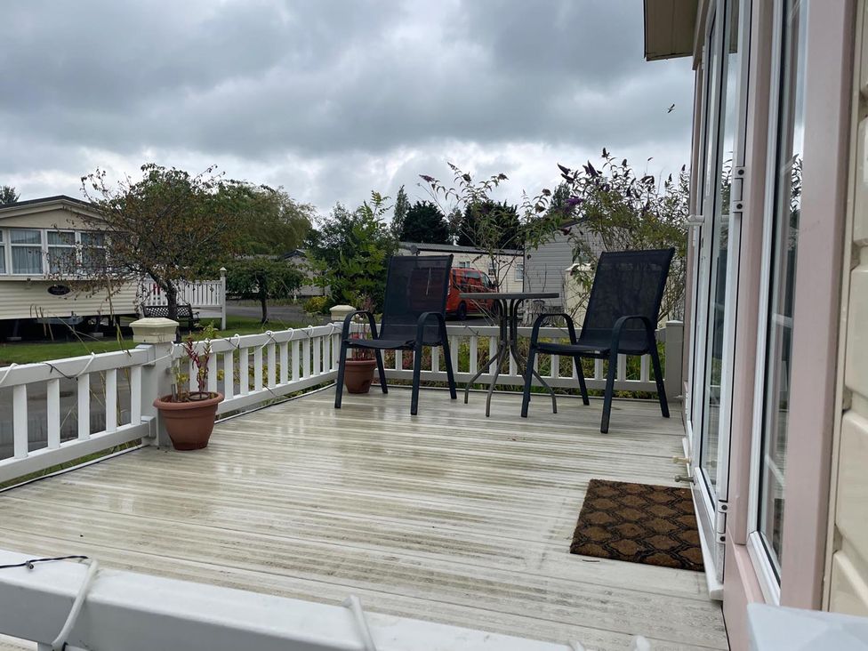 A outdoor patio with two chairs and a table at 2 Bed Lodge Sleeps 5 - Pet Friendly, WiFi, Parking in Skegness