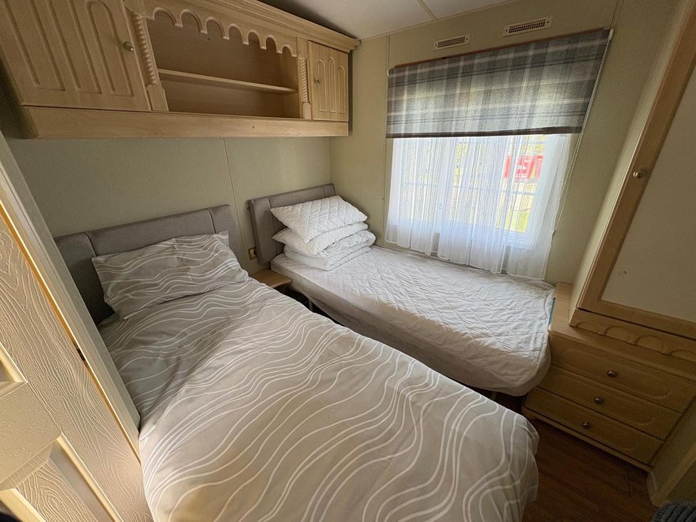 A bedroom with two beds and a window at 2 Bed Lodge Sleeps 5 - Pet Friendly, WiFi, Parking in Skegness