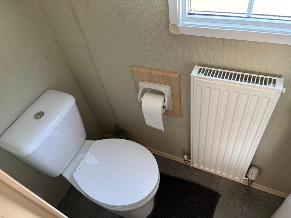A bathroom with a toilet and radiator at 2 Bed Lodge Sleeps 5 - Pet Friendly, WiFi, Parking, Skegness