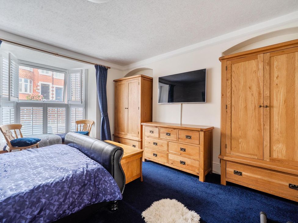 A bedroom with a bed and wooden furniture at 1 Bed - Sleeps 4 - Parking - Pets - Town Centre Wadebridge
