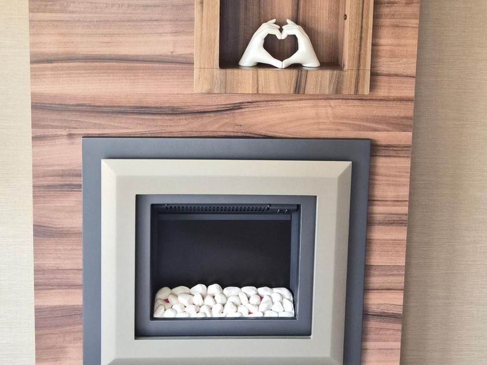 A fireplace with decorative object above at Cabin - Sleeps 6 - Outdoor Pool and Parking, Cenarth