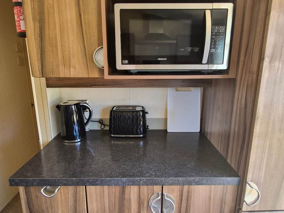 A kitchen with a microwave, kettle, and toaster at Cabin - Sleeps 6 - Outdoor Pool and Parking in Cenarth