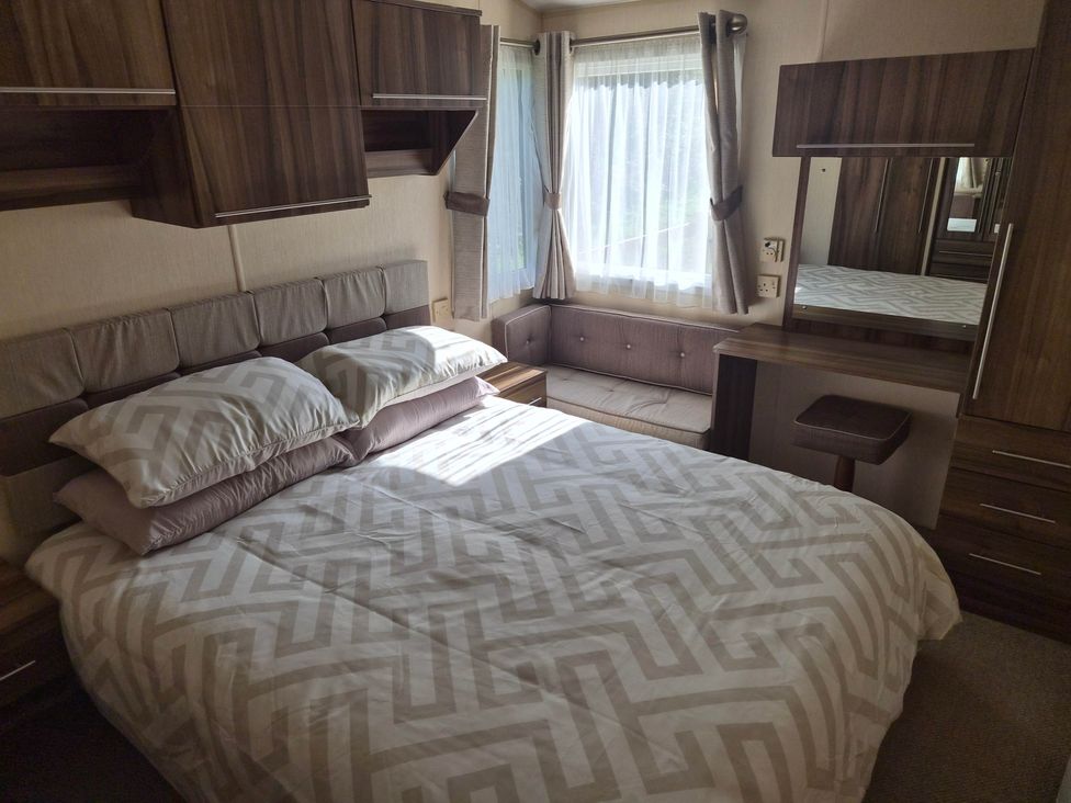 A bedroom with a bed, mirror, and couch at Cabin - Sleeps 6 - Outdoor Pool and Parking, Cenarth