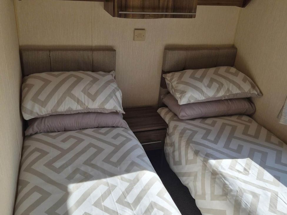 A bedroom with two beds and a nightstand at Cabin - Sleeps 6 - Outdoor Pool and Parking in Cenarth