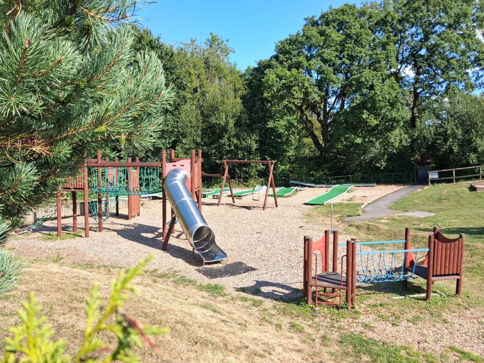 A playground with a slide and swings at a park in Cenarth