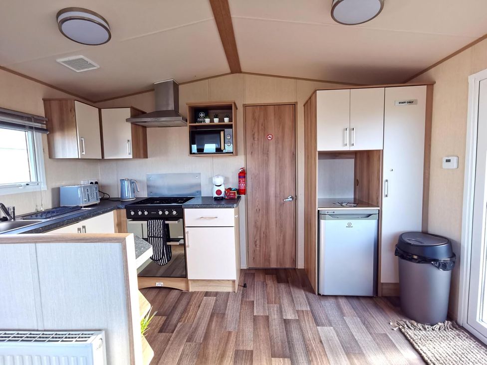 A kitchen equipped with appliances at Snowdonia Sunbeach Holiday Sea and Mountain view in Llwyngwril