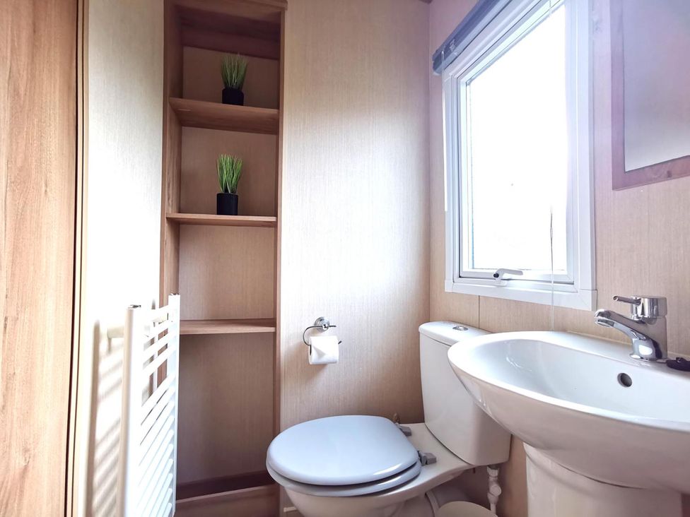 A bathroom with a toilet and sink at Snowdonia Sunbeach Holiday Sea and Mountain view, Llwyngwril