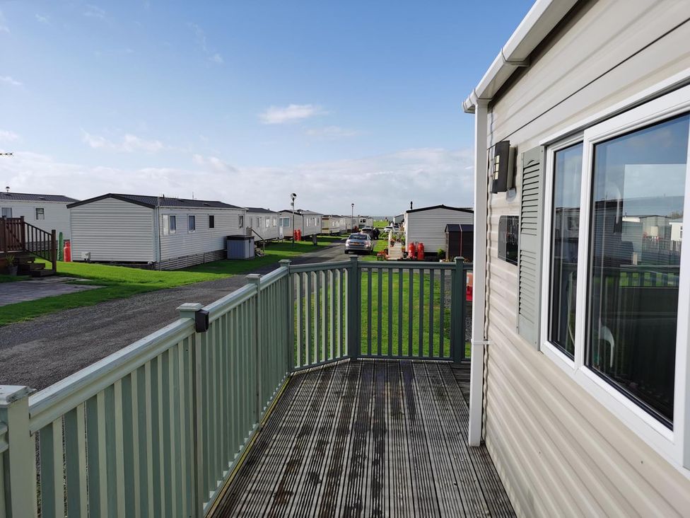 A view from a deck showing mobile homes and a road at Snowdonia Sunbeach Holiday Sea and Mountain view Llwyngwril