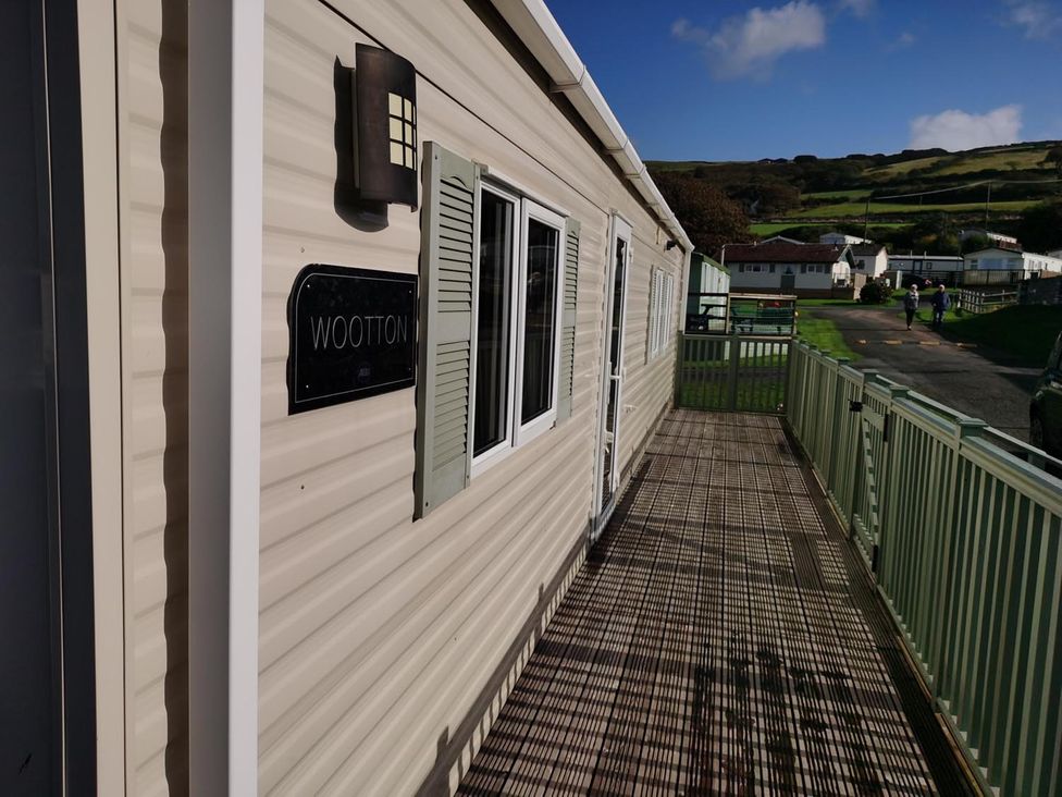 A mobile home with a deck and light fixture at Snowdonia Sunbeach Holiday Sea and Mountain view in Llwyngwril