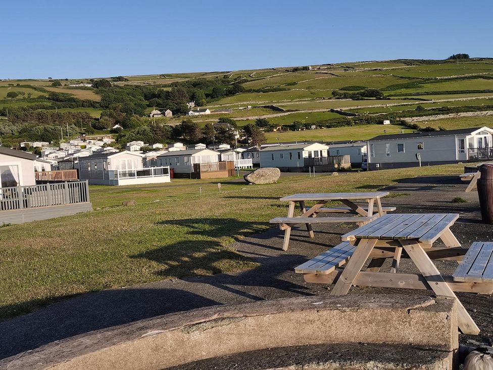 An outdoor area with picnic tables and caravans at Snowdonia Sunbeach Holiday Sea and Mountain view Llwyngwril