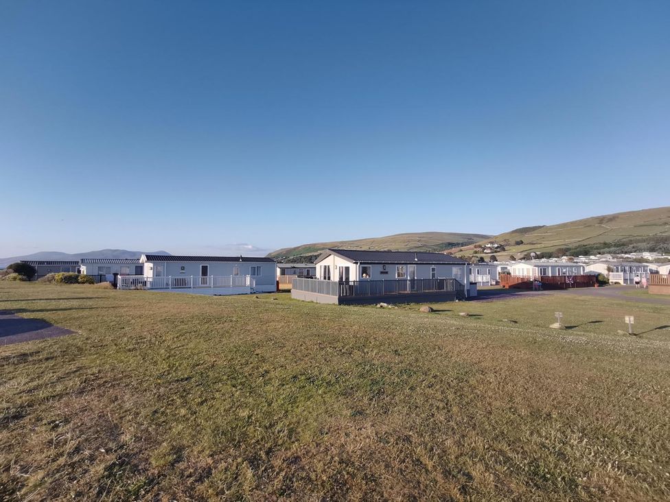 A view of mobile homes in a grassy area at Snowdonia Sunbeach Holiday Sea and Mountain view, Llwyngwril