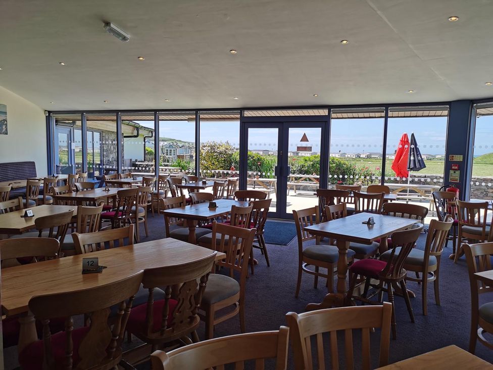 A dining room with tables and chairs at Snowdonia Sunbeach Holiday Sea and Mountain view in Llwyngwril