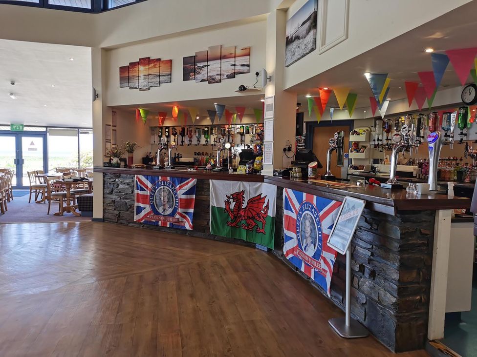 A bar area with seating and flags at Snowdonia Sunbeach Holiday Sea and Mountain view in Llwyngwril