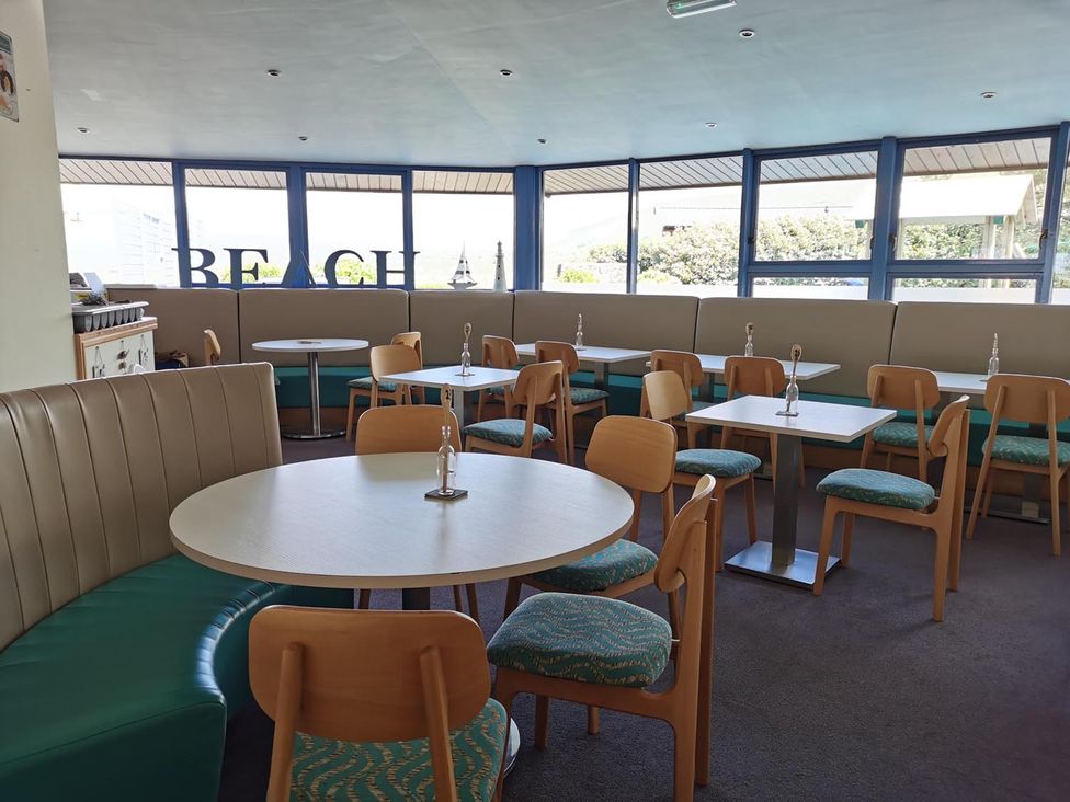 A dining room with tables and chairs at Snowdonia Sunbeach Holiday Sea and Mountain view Llwyngwril