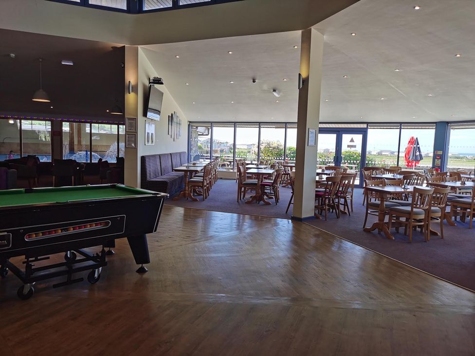 A dining area with a pool table and tables at Snowdonia Sunbeach Holiday Sea and Mountain view in Llwyngwril
