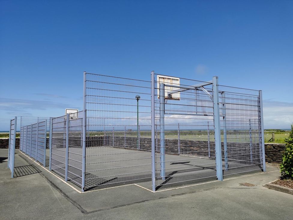 A basketball court enclosed by fencing at Snowdonia Sunbeach Holiday Sea and Mountain view Llwyngwril