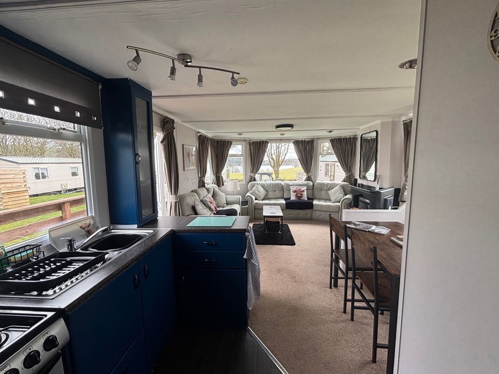 A kitchen and living room area at No 38 Heilan Hoose at Three Lochs Holiday Park near Newton Stewart