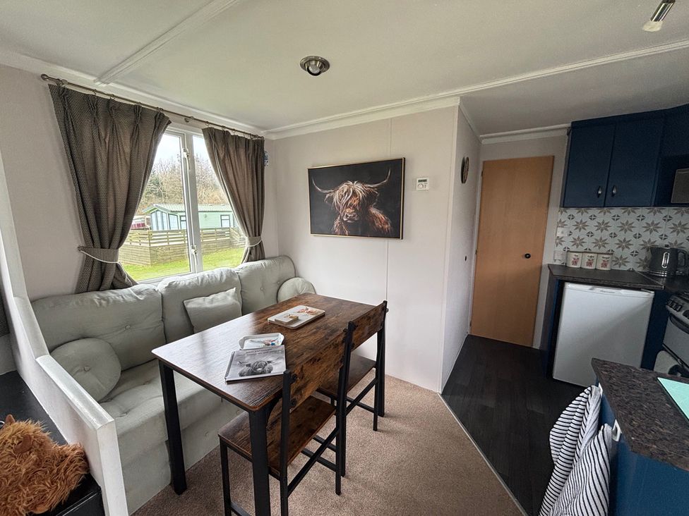 A dining room with a table and chairs at No 38 Heilan Hoose at Three Lochs Newton Stewart