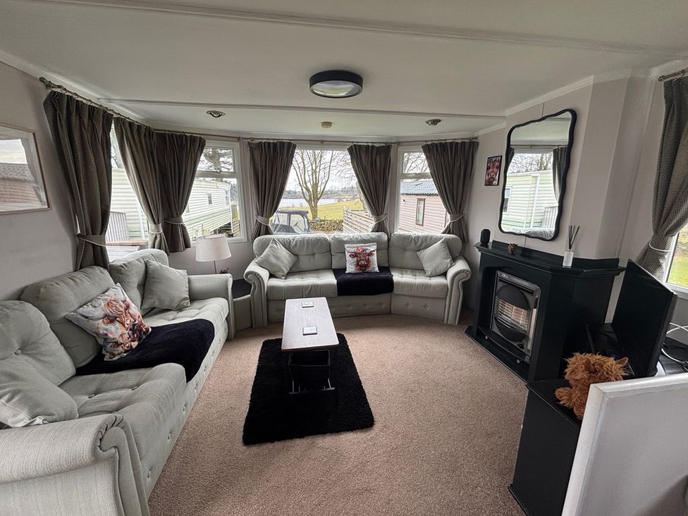 A living room with sofas and a coffee table at No 38 Heilan Hoose at Three Lochs Newton Stewart