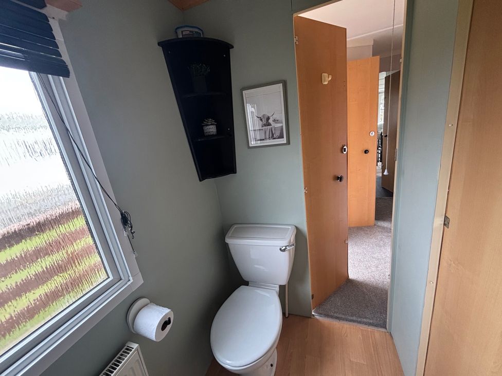 A bathroom with toilet and window at No 38 Heilan Hoose at Three Lochs Newton Stewart
