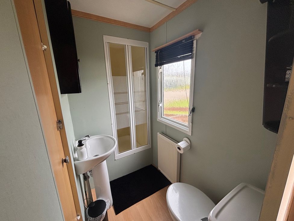 A bathroom with a sink, shower, and toilet at No 38 Heilan Hoose at Three Lochs Newton Stewart