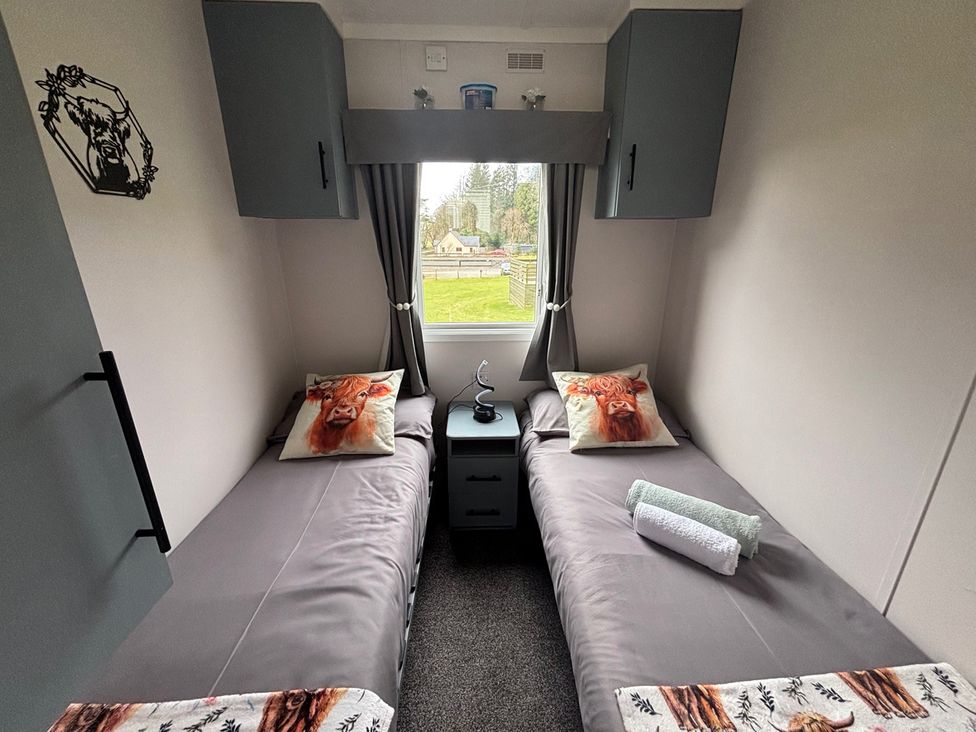A bedroom with two beds and a window at No 38 Heilan Hoose at Three Lochs Newton Stewart
