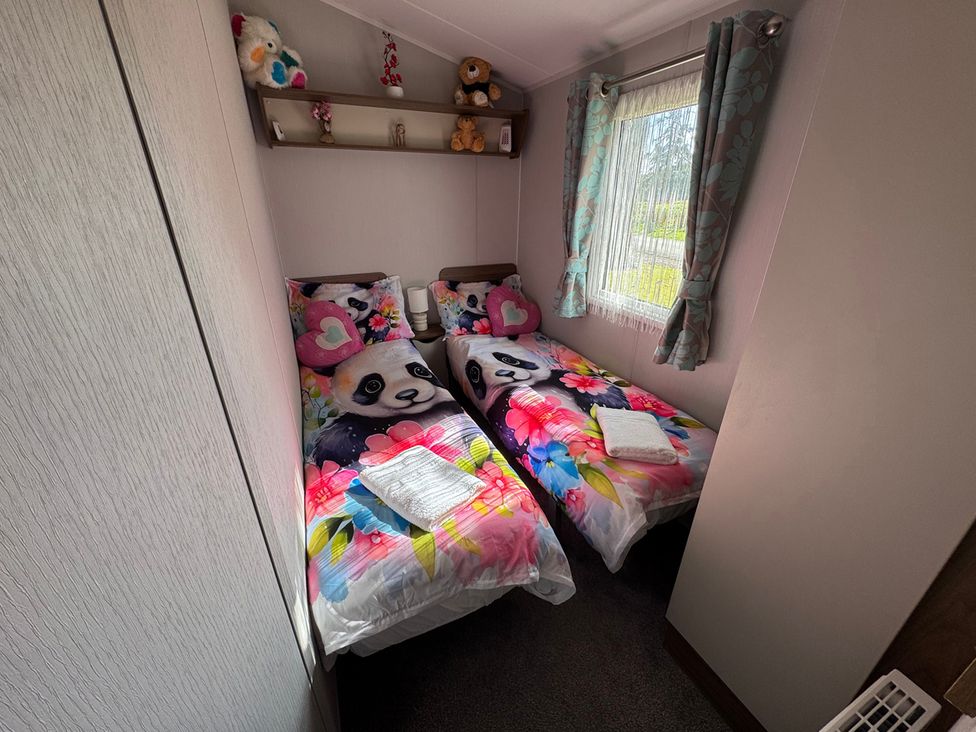 A bedroom with two beds and a shelf at Wl34 Caravan Haggerston Castle Private Decking Haggerston