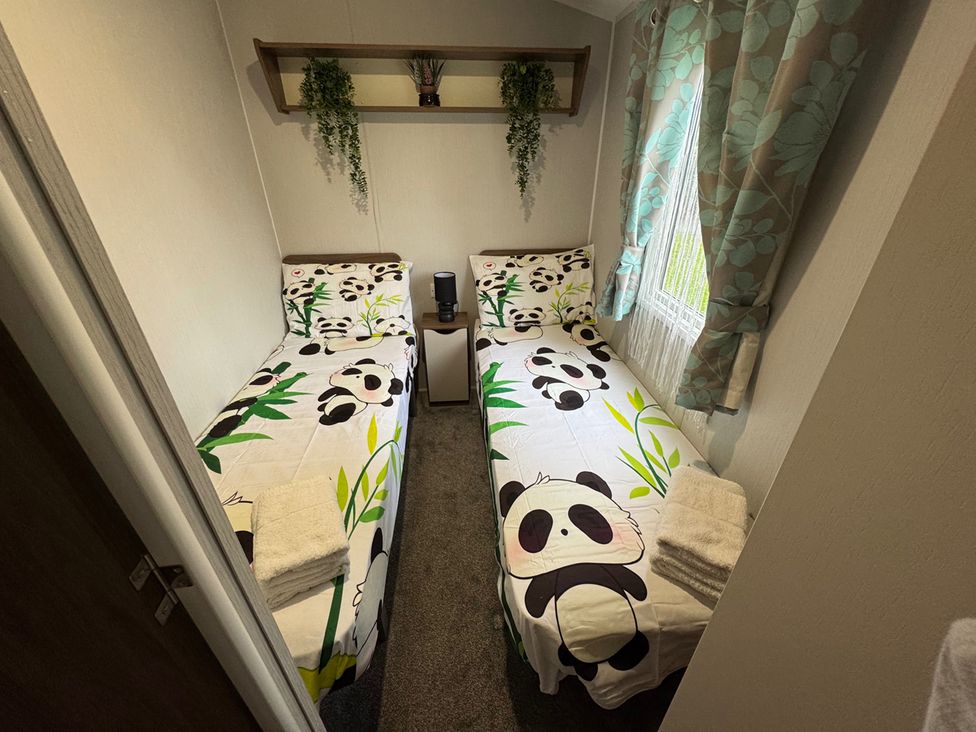 A bedroom with two beds and panda-themed bedding at Wl34 Caravan Haggerston Castle Private Decking Haggerston