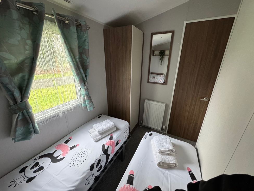 A bedroom with beds and a wardrobe at Wl34 Caravan Haggerston Castle Private Decking Haggerston