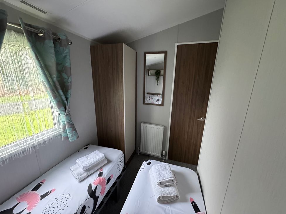 A bedroom with two beds and towels on top at Wl34 Caravan Haggerston Castle Private Decking Haggerston