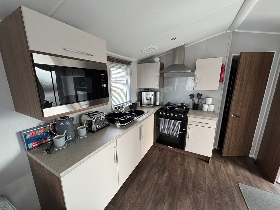 A kitchen with appliances and storage at Wl34 Caravan Haggerston Castle Private Decking Haggerston