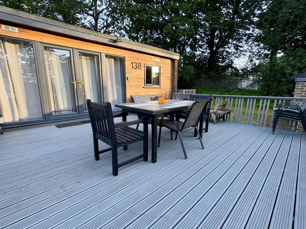 An outdoor patio with a table and chairs at Pet Friendly 2-Bed Lodge, Sleeps 5, Pool & Parking in Caernarfon