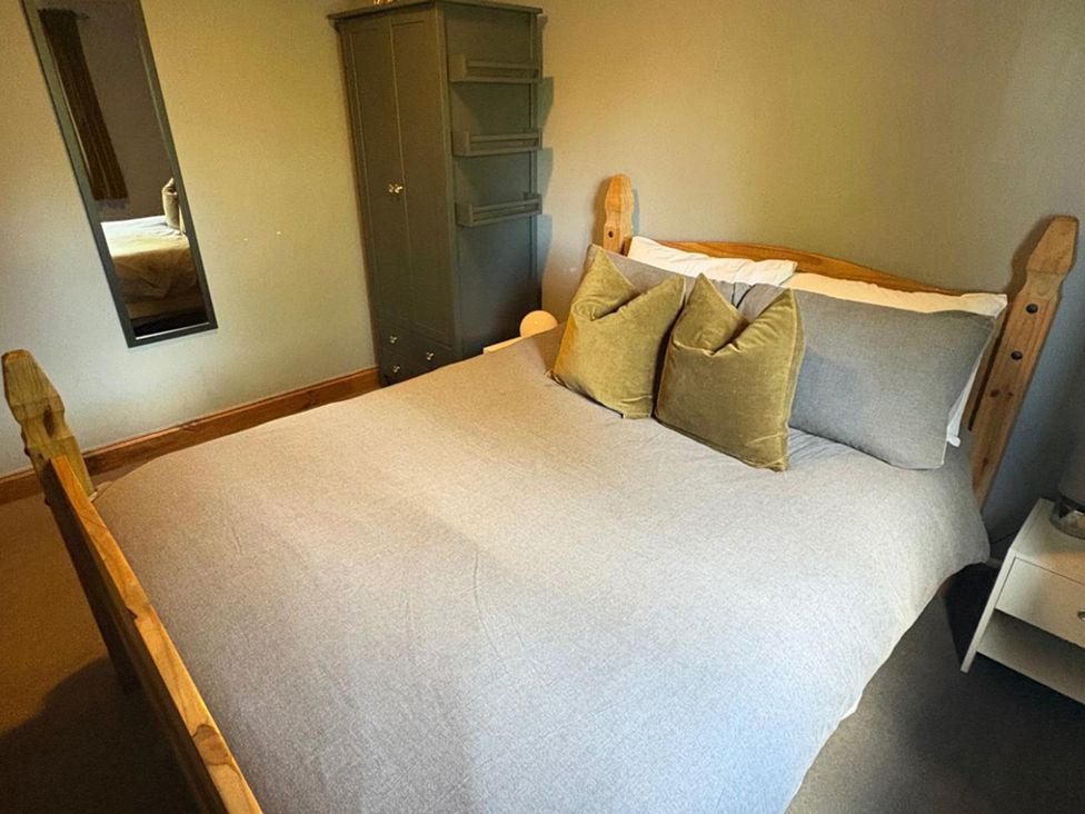 A bedroom with a bed and wardrobe at Pet Friendly 2-Bed Lodge, Sleeps 5, Pool & Parking, Caernarfon
