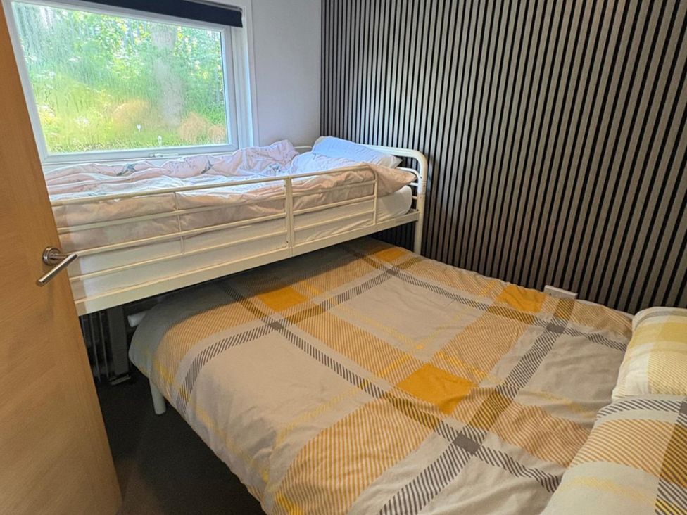 A bedroom with a bunk bed and a double bed at Pet Friendly 2-Bed Lodge, Sleeps 5, Pool & Parking, Caernarfon