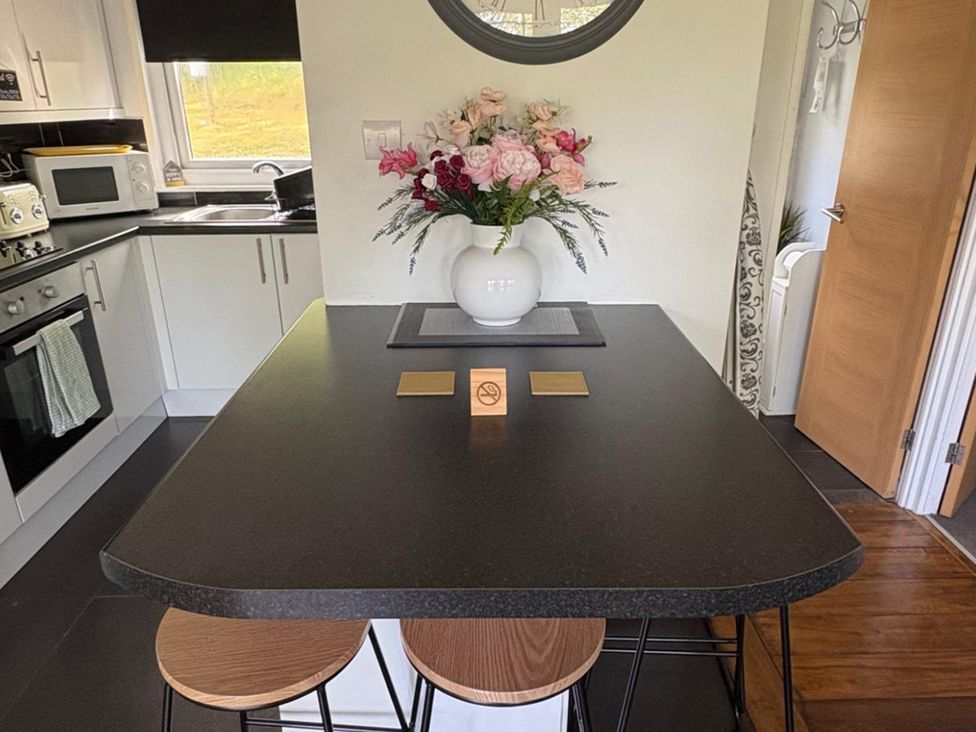 A kitchen with a counter and flower vase at Pet Friendly 2-Bed Lodge, Sleeps 5, Pool & Parking, Caernarfon