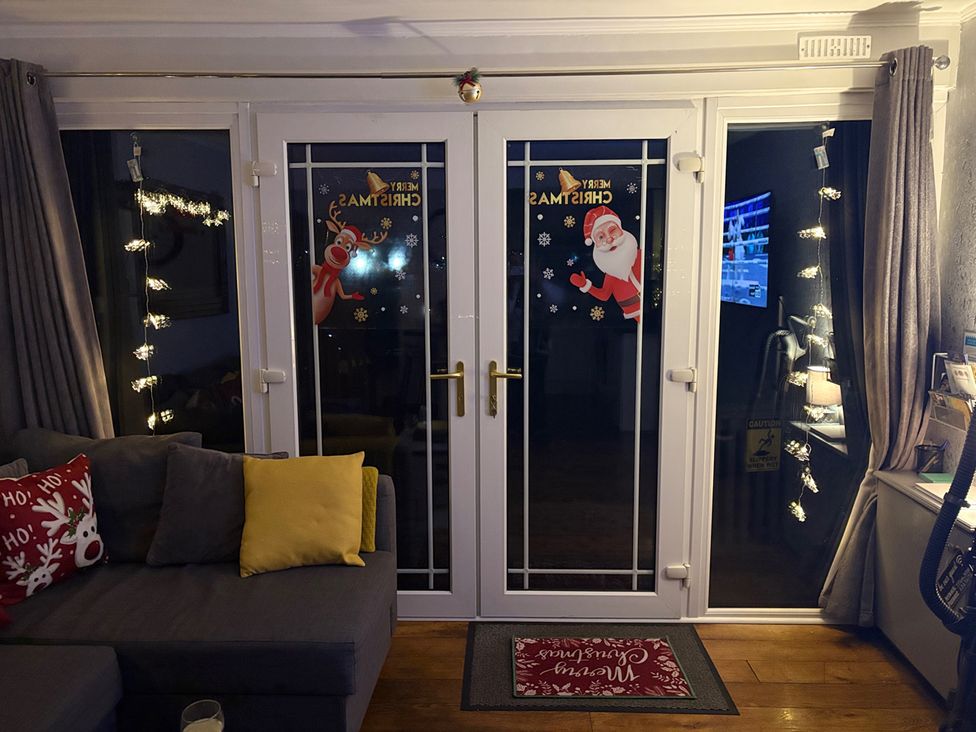 A snug with sliding glass doors decorated for Christmas at Pet Friendly 2-Bed Lodge, Sleeps 5, Pool & Parking, Caernarfon