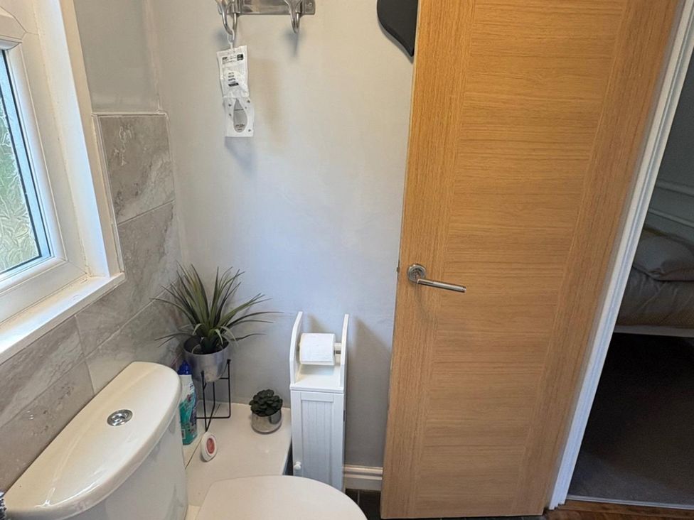 A bathroom with a toilet and window at Pet Friendly 2-Bed Lodge, Sleeps 5, Pool & Parking in Caernarfon