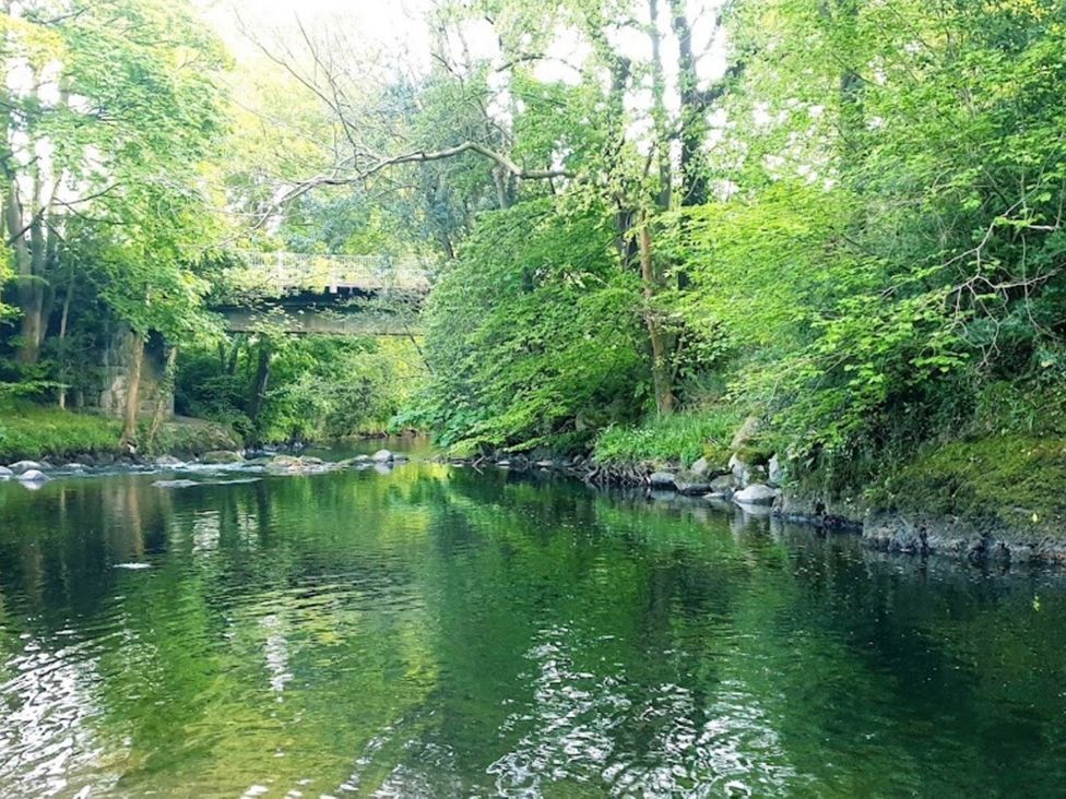 A river surrounded by trees with a bridge overhead at Pet Friendly 2-Bed Lodge, Sleeps 5, Pool & Parking, Caernarfon